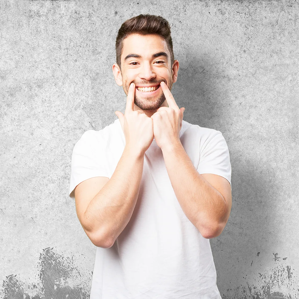 Smiling man pointing to his healthy teeth